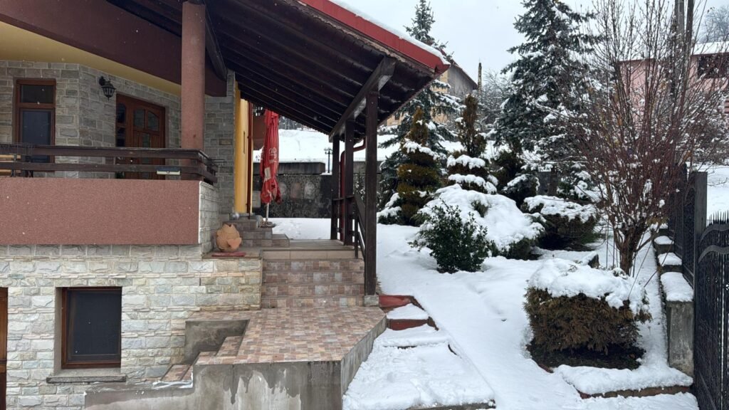 Galerie Scările de la intrarea în pensiune și grădina acoperită de zăpadă